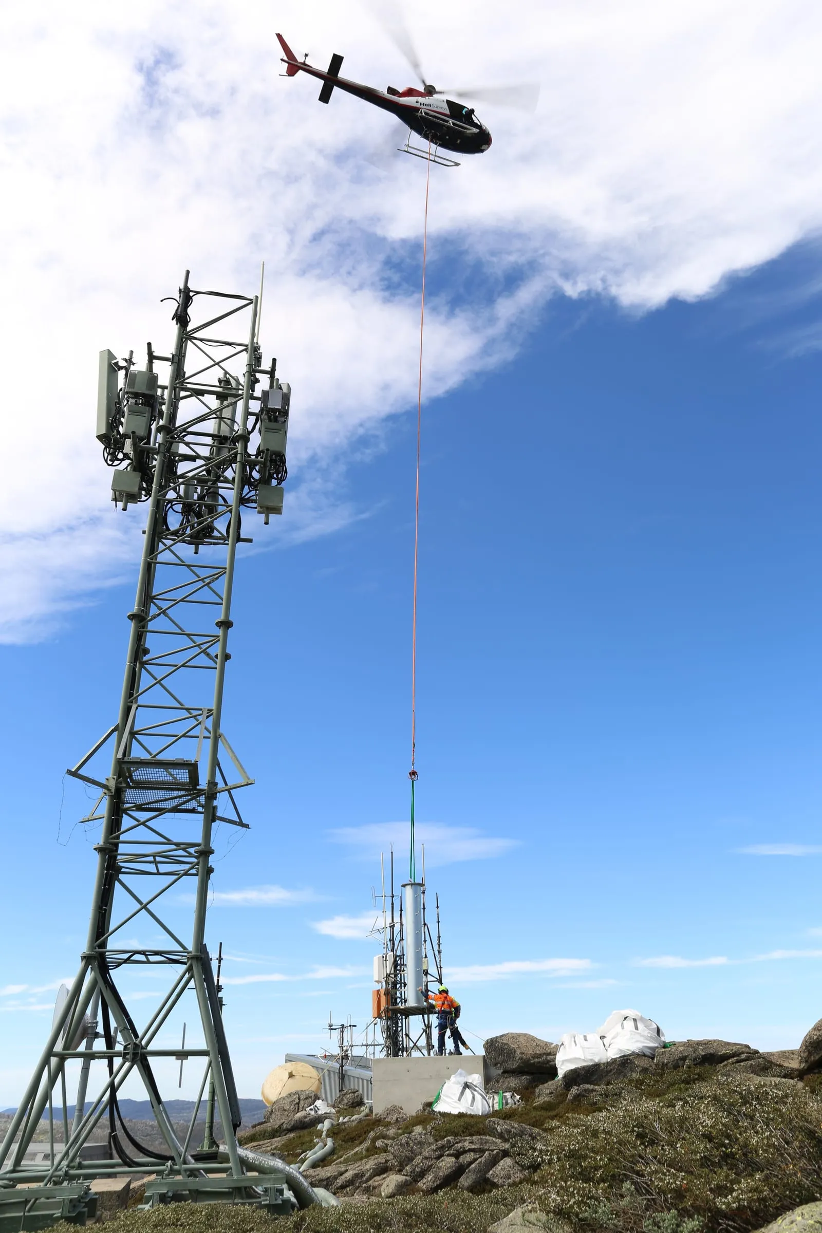 Splendid Constructions crew installing telecommunications infrastructure with helicopter support.